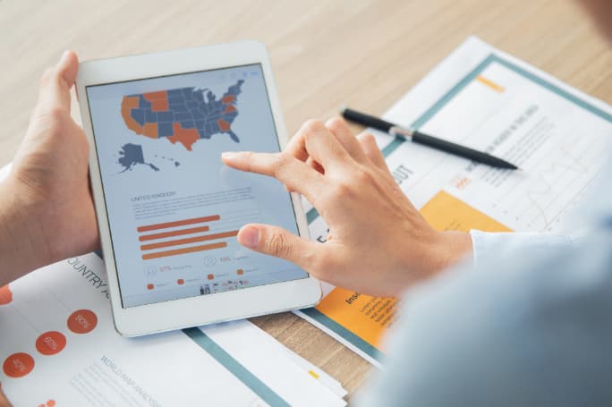 Photo of a person looking at data on a digital tablet