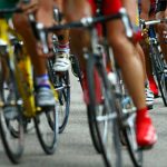 close up of group of cyclists wheels and feet