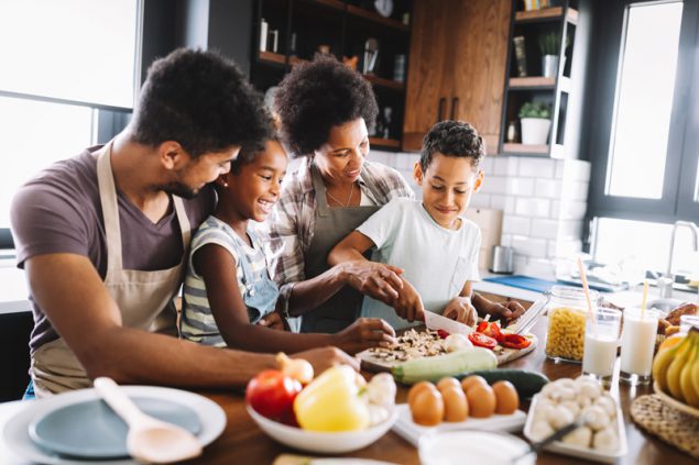 Una feliz familia afroamericana preparando una comida saludable en la cocina