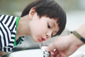 Young boy drinking water from a fountain