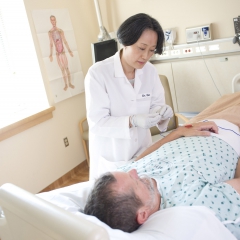 An acupuncturist works with a patient.