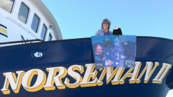 Teacher at Sea Mary Cook and school mascot Qanuk the Eagle show off a banner created by Scammon Bay School's 4th Grade class on board R/V Norseman II.