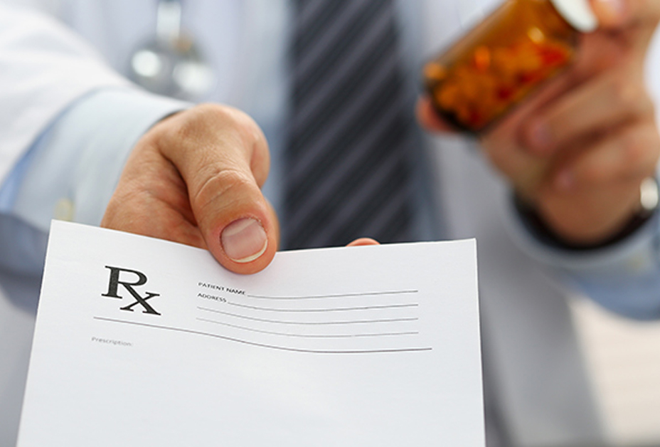 Pharmacist holding prescription and bottle of pills