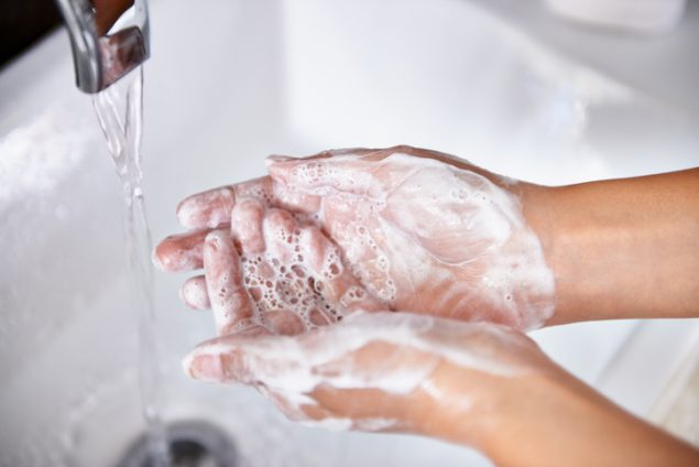 washing hands under faucet