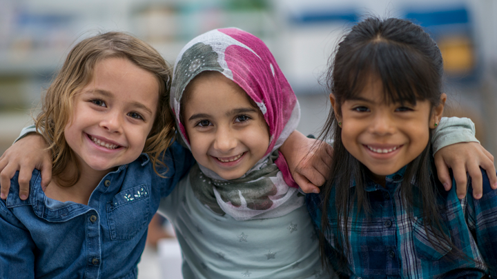 Image of three smiling girls with their arms around each other