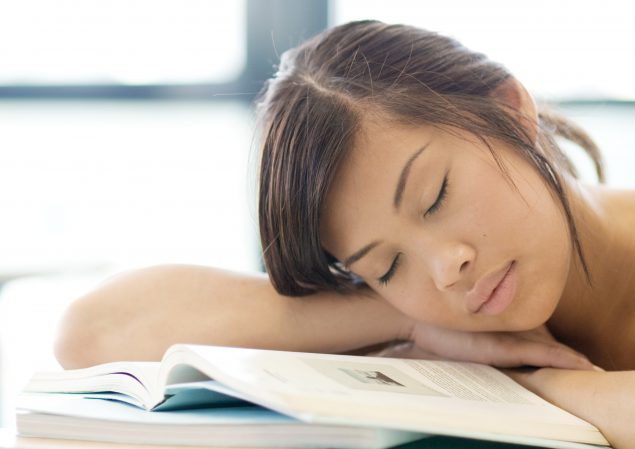 Student sleeping on textbook