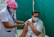 Health worker administering injection to woman (© Sam Panthaky/AFP/Getty Images)