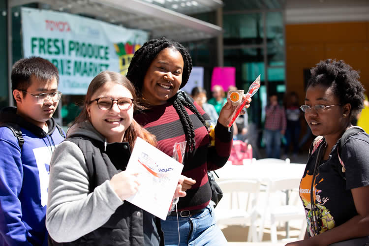 UNTD students smile as they sample food.