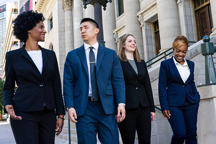 College of Law students walk along the sidewalk.